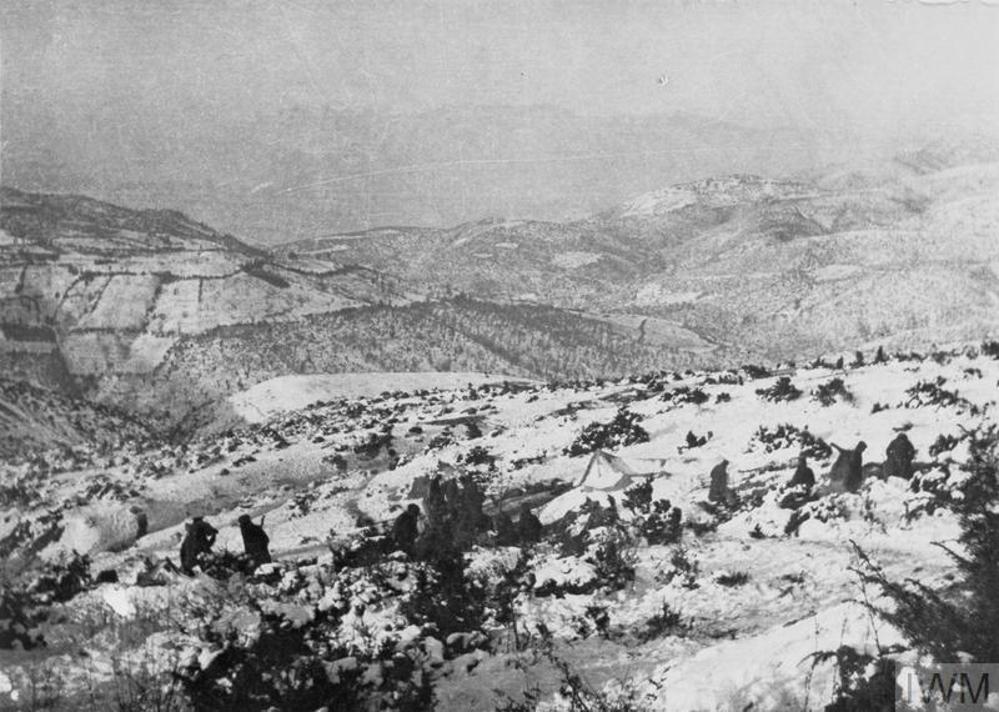 HQ of the Connaught Rifles tucked in the hills of Salonkia. A number of soldiers' silhouettes are visible against the snow but the HQ tents are hard to discern.