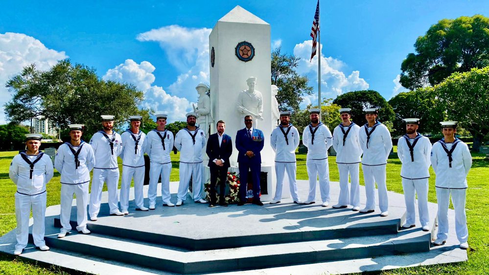 British Naval crewmen pose on the steps of an American naval memorial in their clean, crisp white naval uniforms, for Remembrance Day.