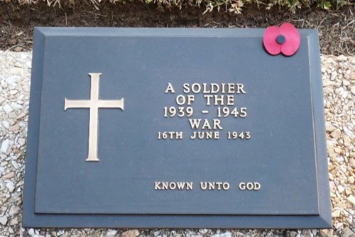 A black memorial black for an unknown casualty of the Second World War. An embossed gold cross is vible to the left. In the centre right is embossed lettering that reads: A Soldier of the 1939-1945 War 16th June 1943 Known Unto God. A red poppy has been placed in the far right corner.