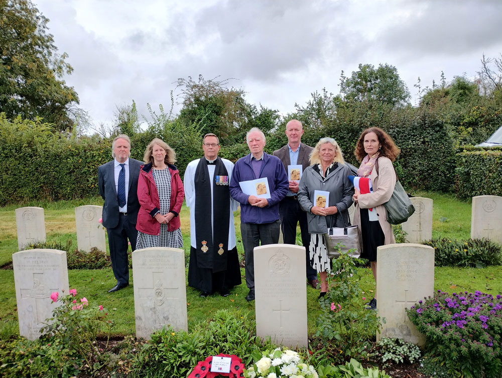 Attendees to CWGC rededication service posing in front of war graves.