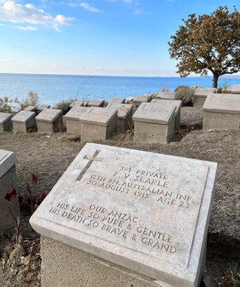 War grave marker of Private F.V Searle overlooking the sea.
