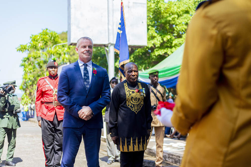 Rich Hills, left, and a Sierra Leonean politician in traditional dress stand ready to lay a wreath at the Freetown Memorial, Sierra Leone
