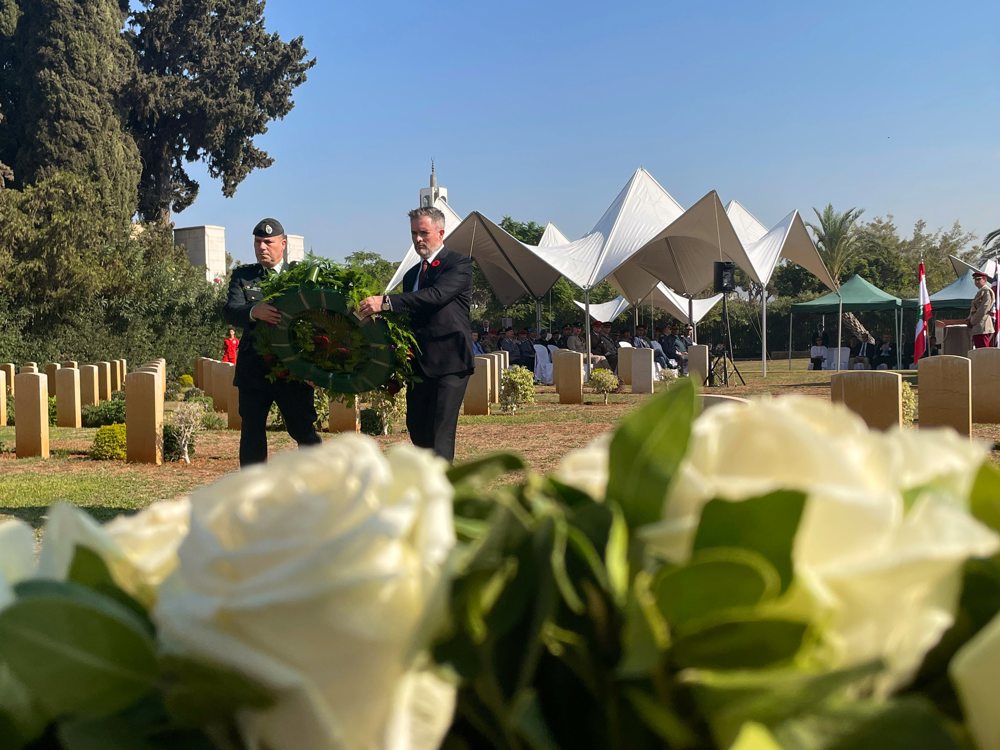 Two men carry a wreath on their way to lay it on the steps of a war memorial in Beirut.