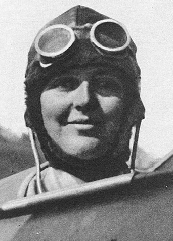 Susan Slade at the cockpit of an aircraft wearing a flying cap with goggles perched on her hat.