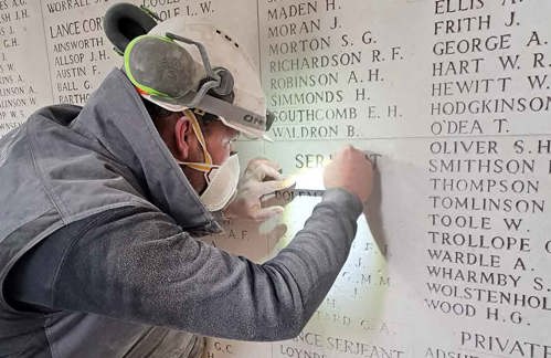 Person works on restoring the name panels on the Menin Gate