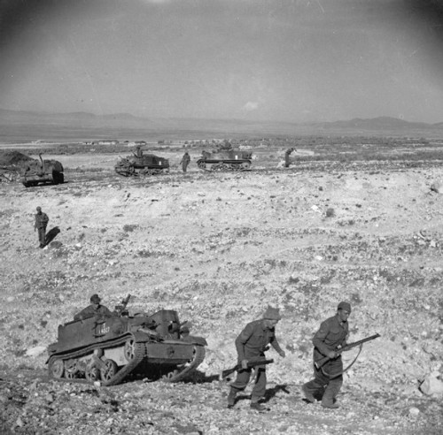 British troops escort universal carriers through the desert.