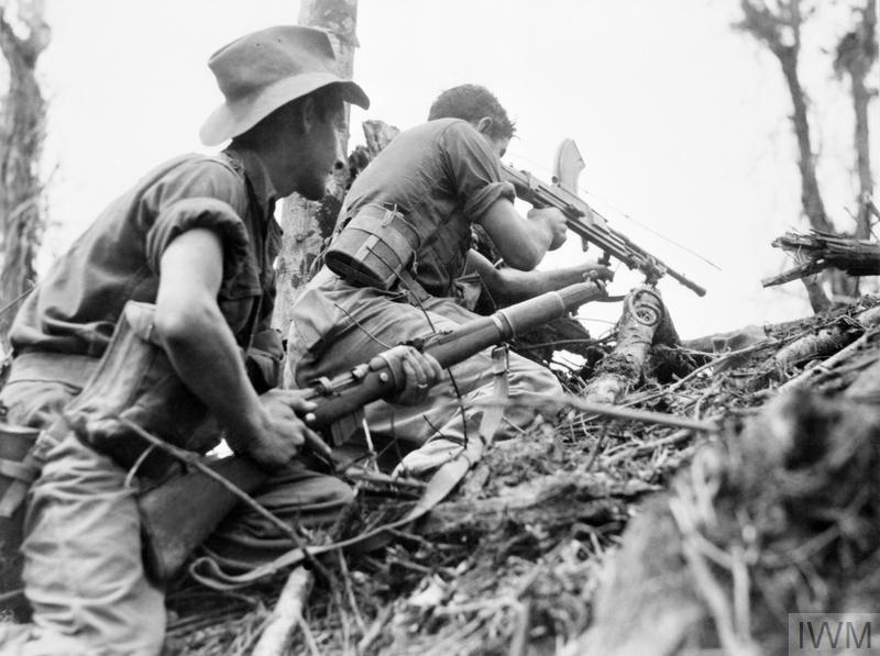 AUstralian infantry in Surge Hats and short fatigues firing at an unseen enemy on Papua New Guinea during the Second World War/