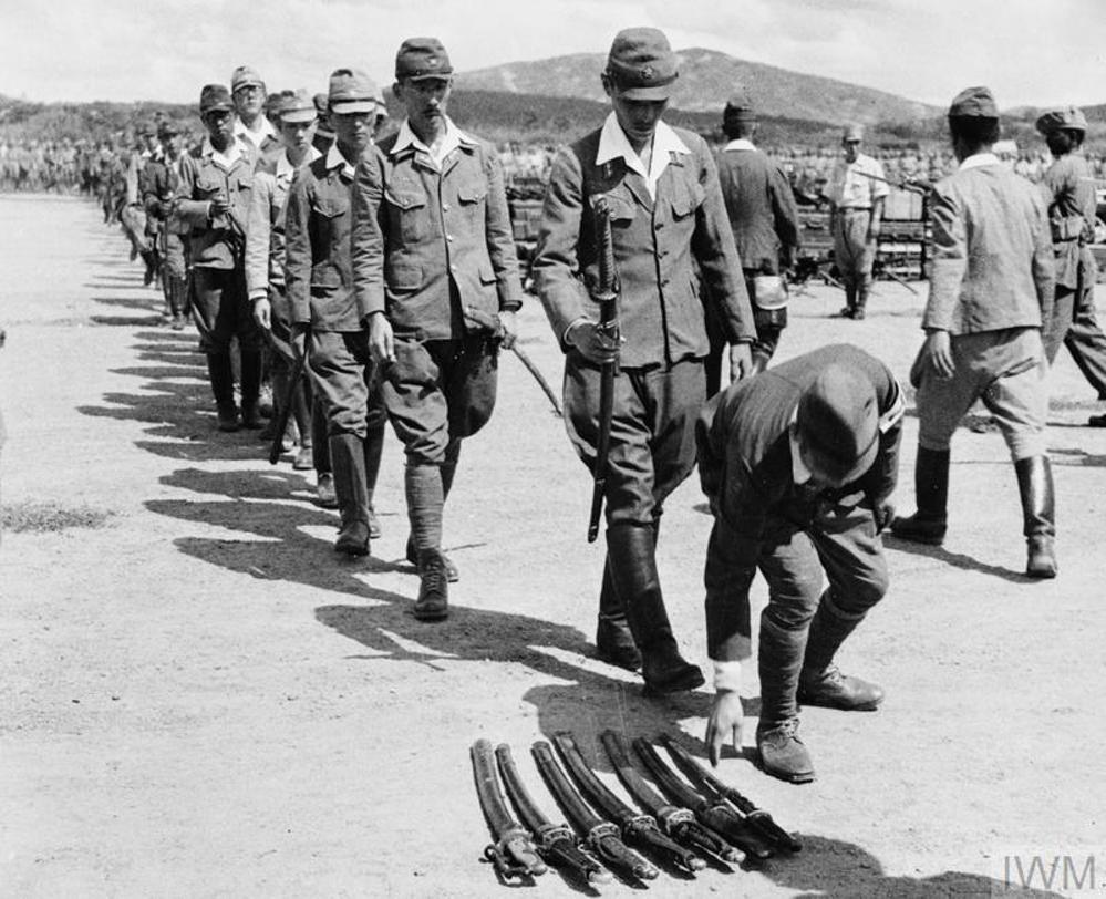 Japanese officers lay their swords on the ground in an act of surrender to British authorities in Malaysia, circa August 1945.
