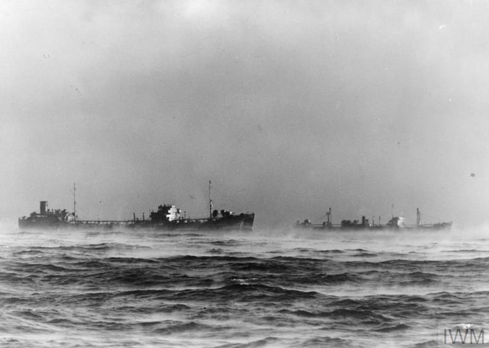 A Merchant Navy convoy moves across the Arctic Ocean. Fog is rising from the sea.