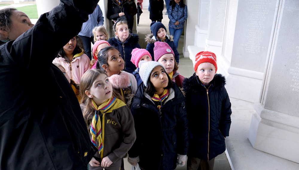 A CWGC tour guide gives young brownies a your of the memorial panels at the Runnymede Memorial